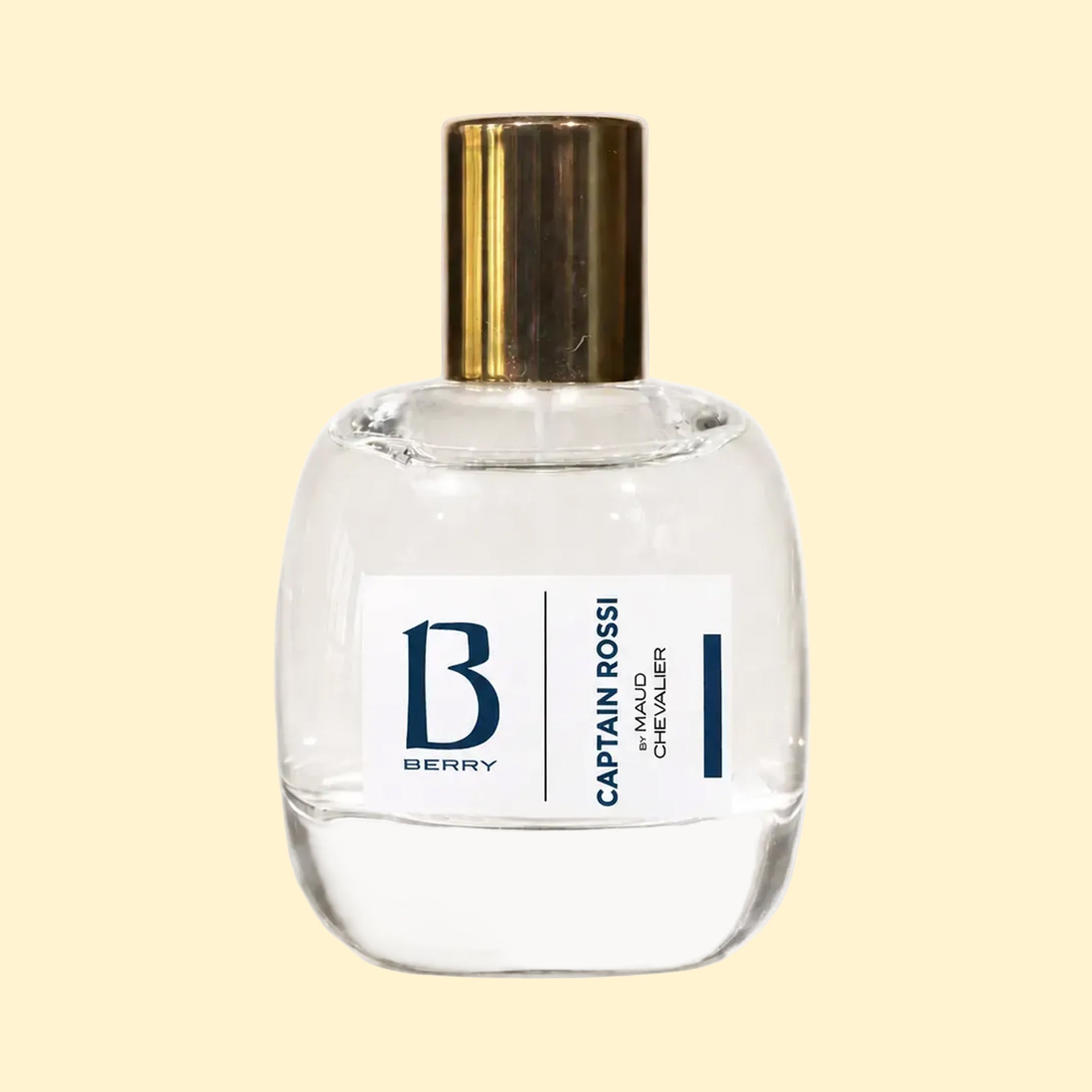 A studio product photograph of a clear glass perfume bottle filled with yellow-green fragrance, topped with a reflective gold cylindrical cap and set against a soft cream background. A white label on the front displays the Parfums Berry logo and the name “Maud Chevalier.” The transparent bottle reveals the luminous colour of the perfume, while soft reflections on the glass emphasise its rounded, sculptural shape.