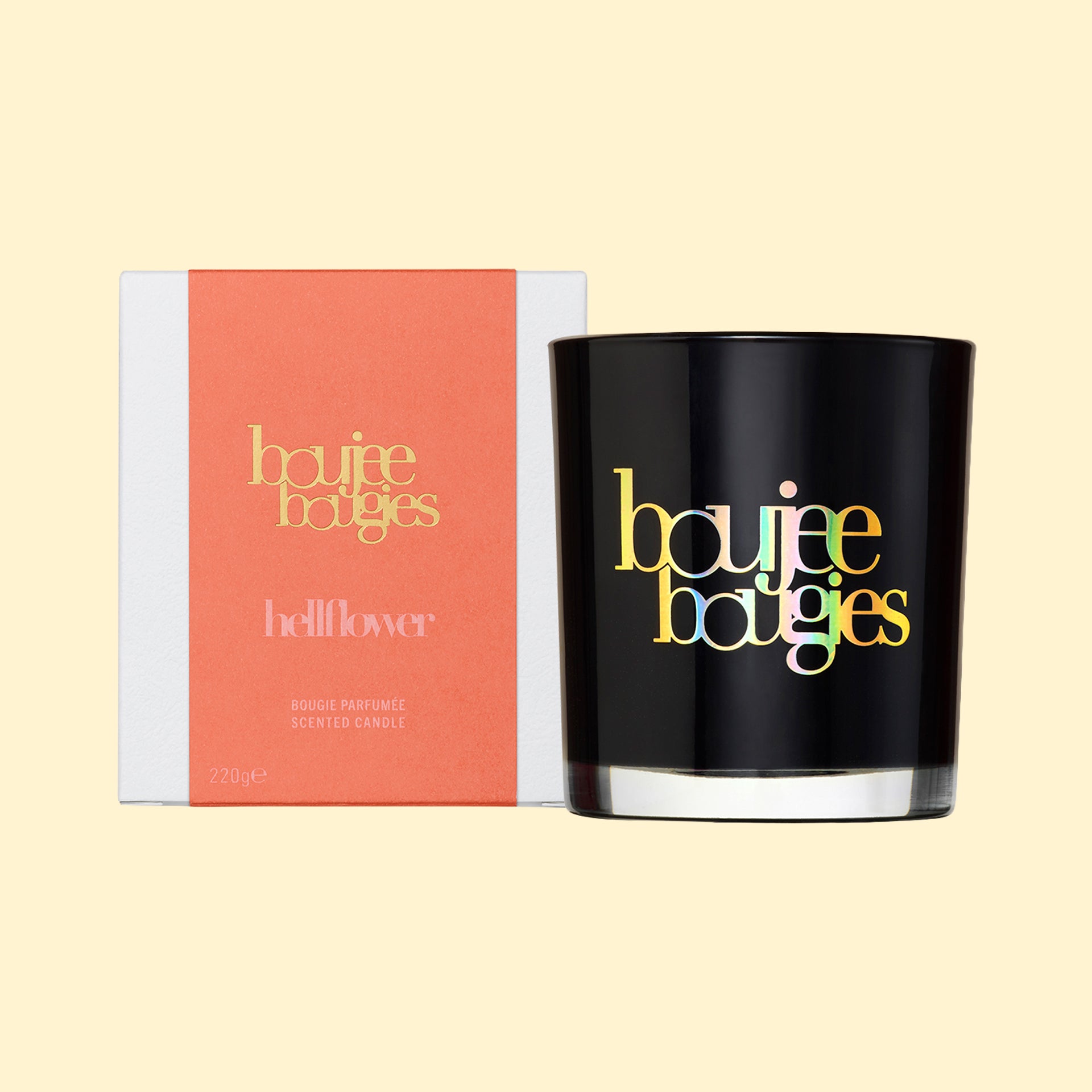 Boujee Bougies Hellflower geurkaars van Olfiction in een glanzend zwart glazen glas naast de koraalkleurige en witte verpakking, 220g.