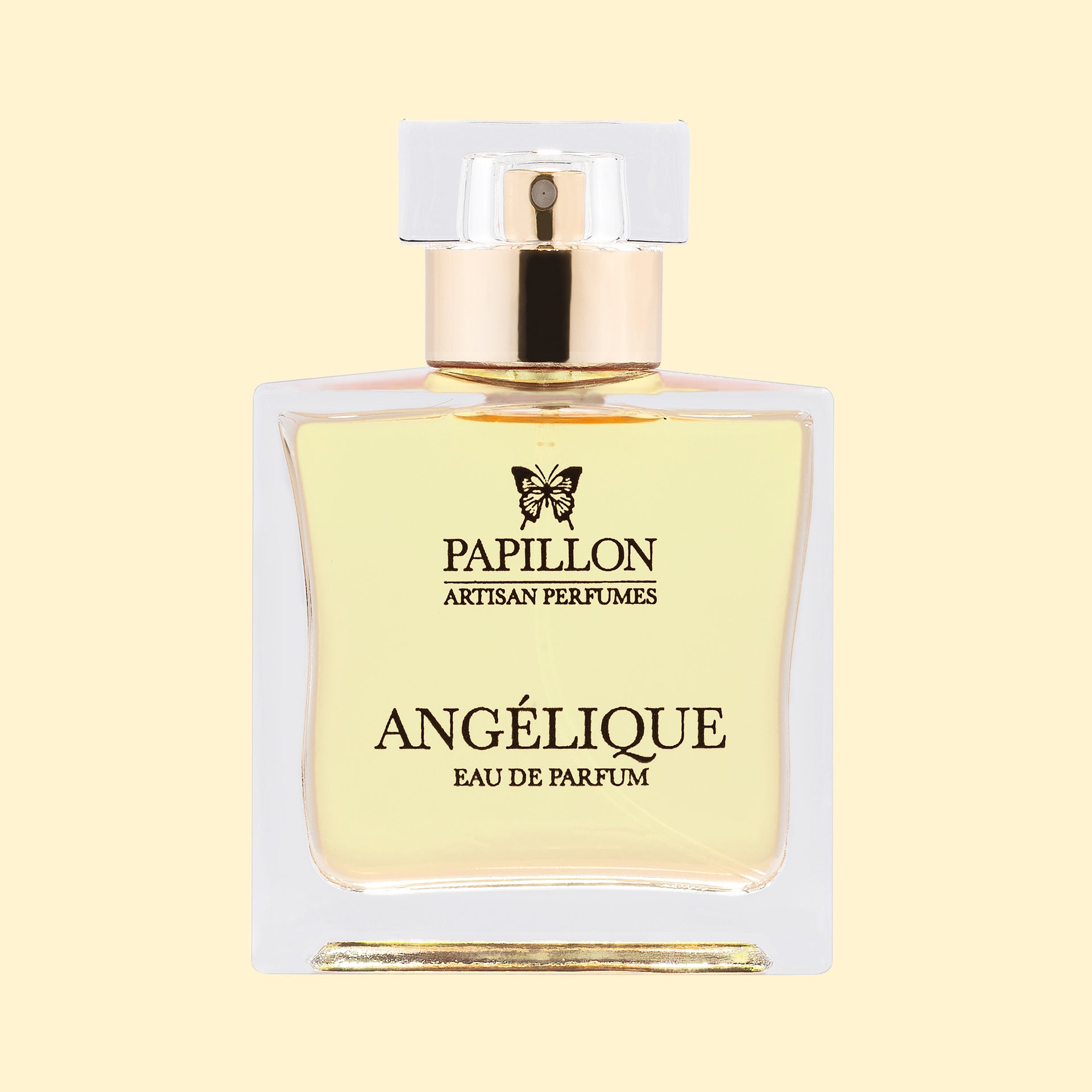 Papillon Artisan Perfumes Angélique Eau de Parfum in a clear rectangular glass bottle with a white cap and gold collar, filled with pale straw-coloured fragrance against a soft cream background.