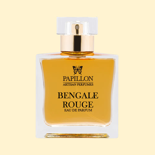 Papillon Artisan Perfumes Bengale Rouge Eau de Parfum in a clear rectangular glass bottle with a white cap and gold collar, filled with warm golden-amber fragrance against a soft cream background.