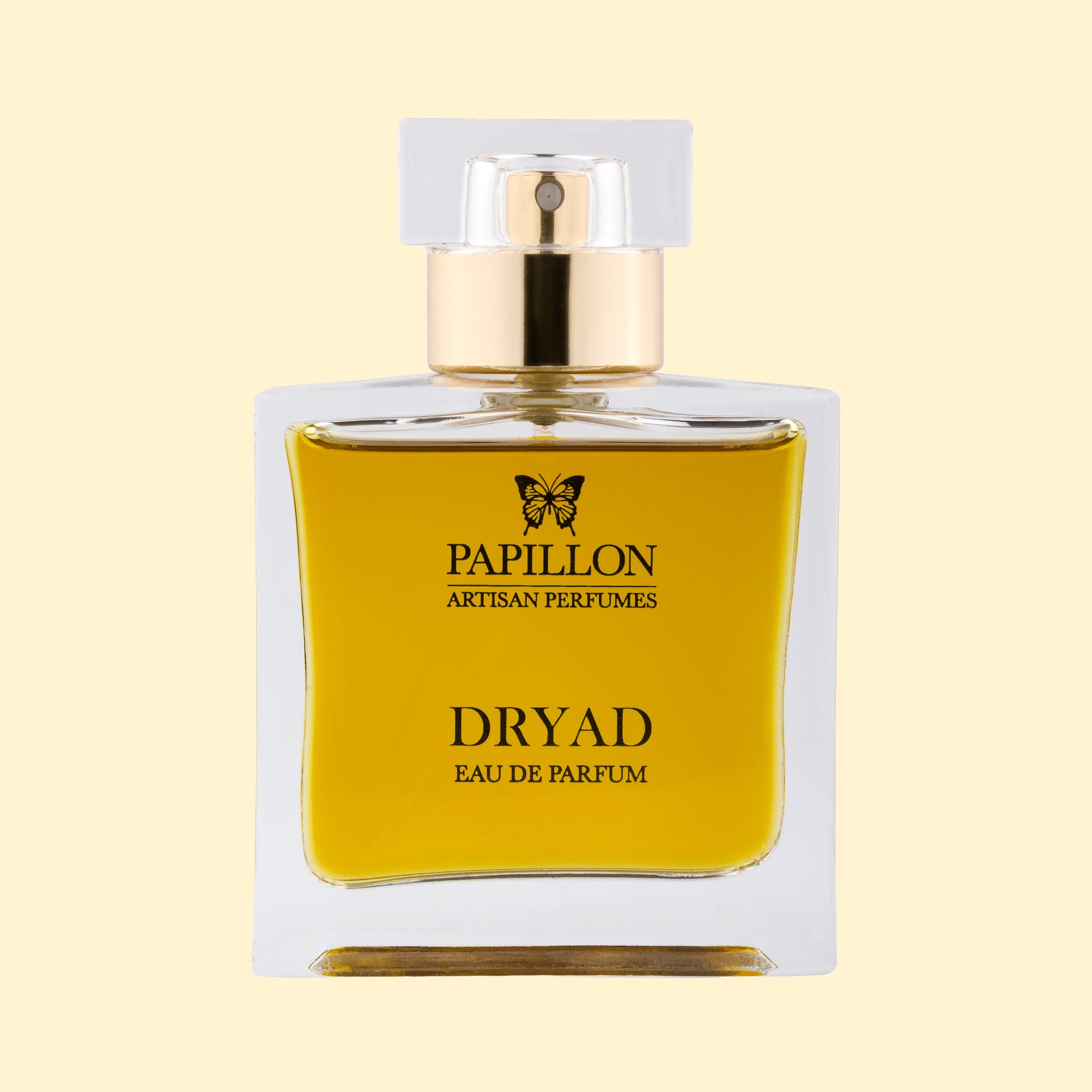 Papillon Artisan Perfumes Dryad Eau de Parfum in a clear rectangular glass bottle with a white cap and gold collar, filled with rich golden-yellow fragrance against a soft cream background.