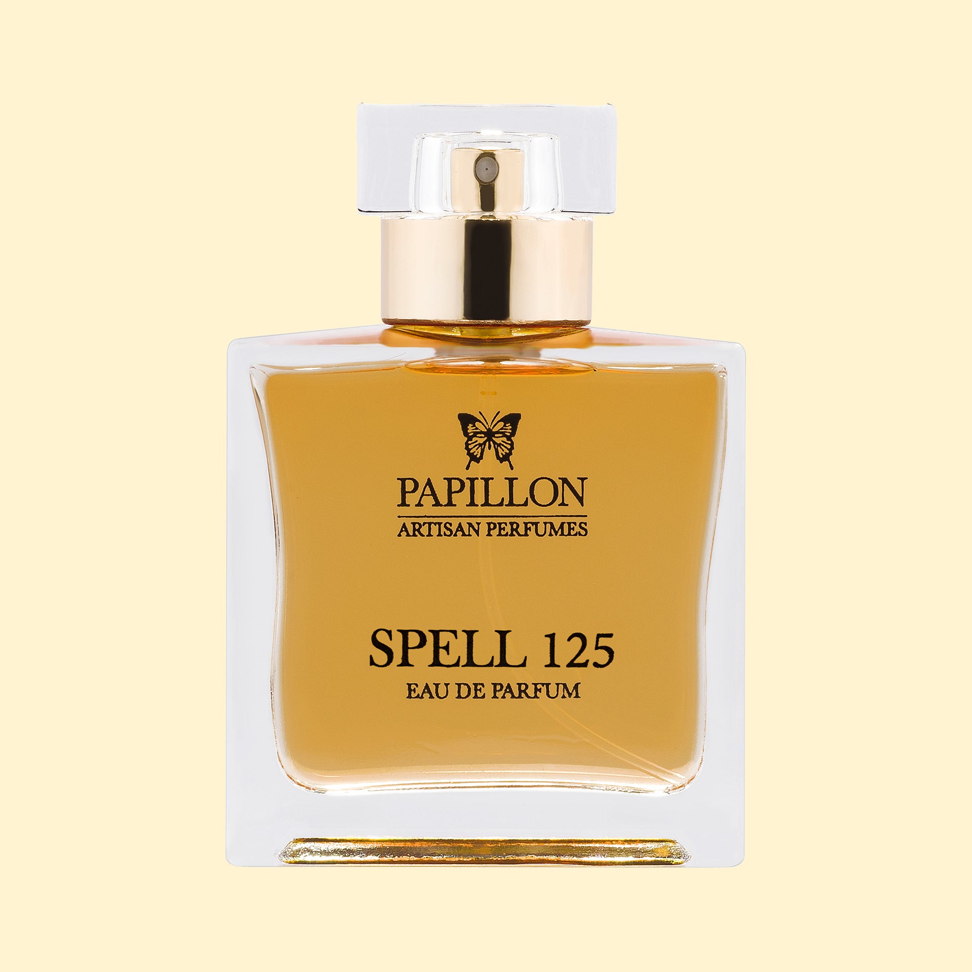 Papillon Artisan Perfumes Spell 125 Eau de Parfum in a clear rectangular glass bottle with a white cap and gold collar, filled with soft amber-gold fragrance against a soft cream background.